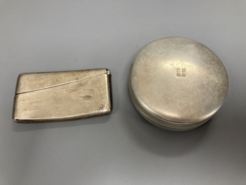 A Chinese white metal concave card case engraved with a dragon, 84mm and a Chinese metal circular box and cover.